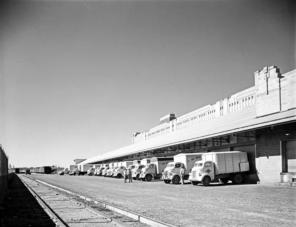 Muelles de carga de un almacén ferroviario en 1946: una fila de camiones esperando junto al andén
